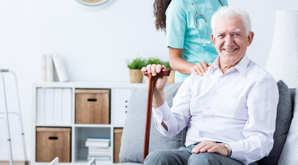 Formación Alzheimer Hombre mayor sentado y una médico detrás de pie