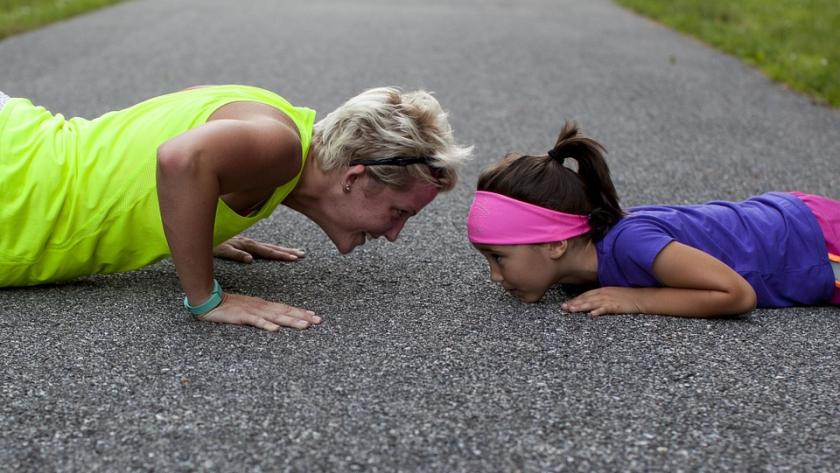 Chica y niña en el suelo haciendo flexion Chica y niña en el suelo haciendo flexion
