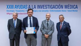 Cuatro hombrees posando el del medio a la izquierda con un diploma los otros un paso atrás