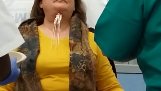 mujer con cabeza levantada y tubos que se insertan en el cuello