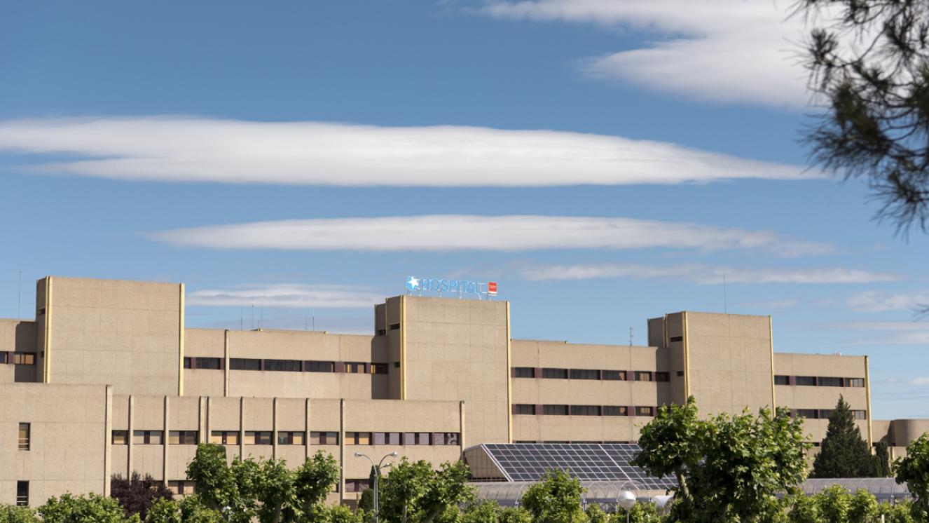 Vista del edificio principal del Hospital de Getafe con nubes y vegetación