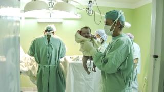 equipo médico sosteniendo un bebé recien nacido