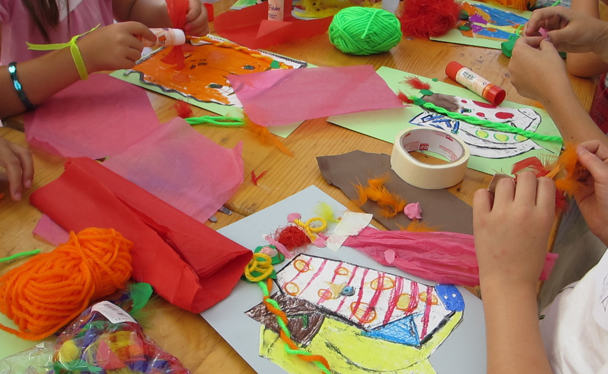 Niños trabajando con pinturas y papeles de colores