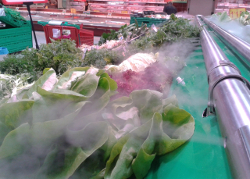 Agua pulverizada sobre un mostrador de verduras