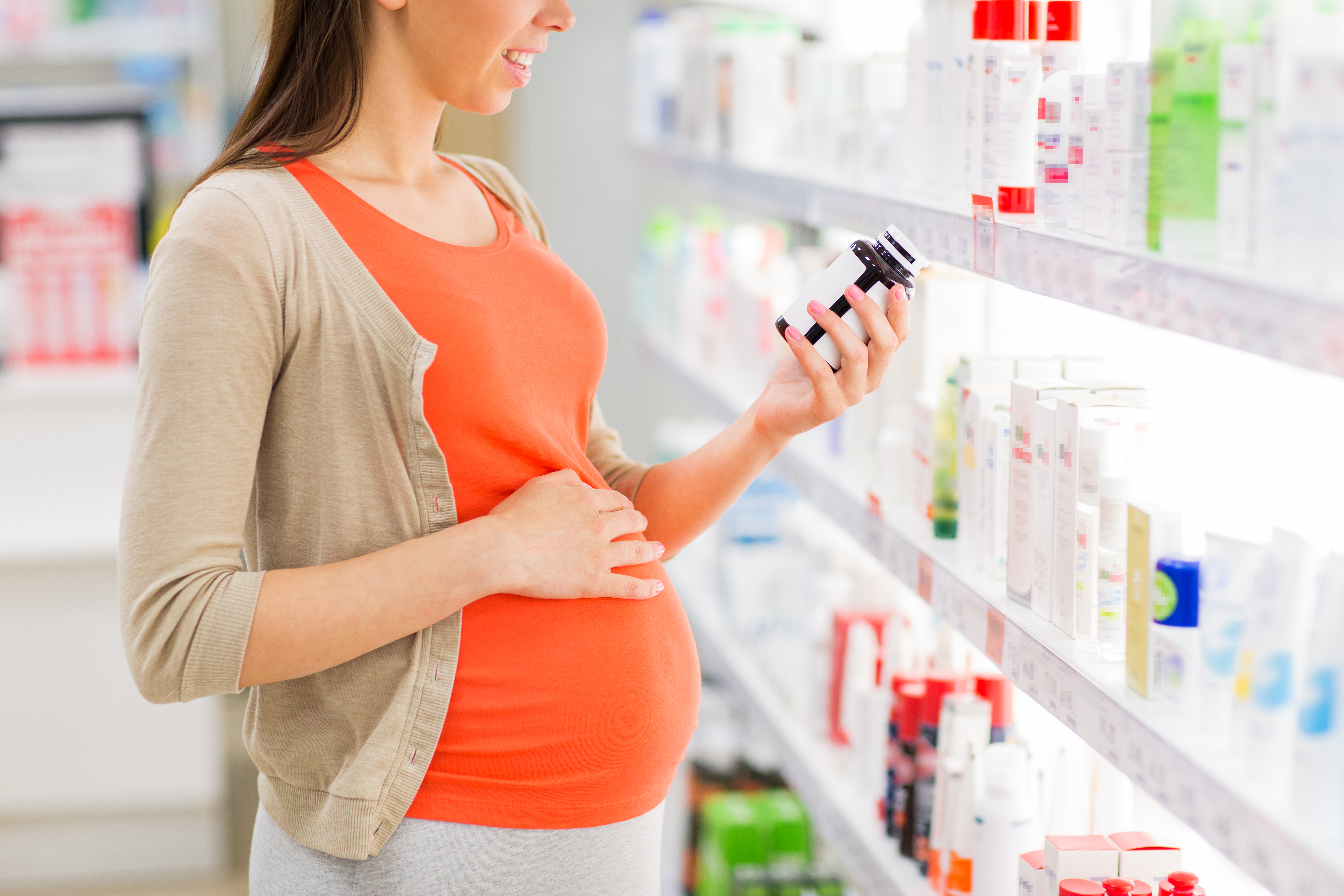señora embarazada en la farmacia mirando la etiqueta de un producto 