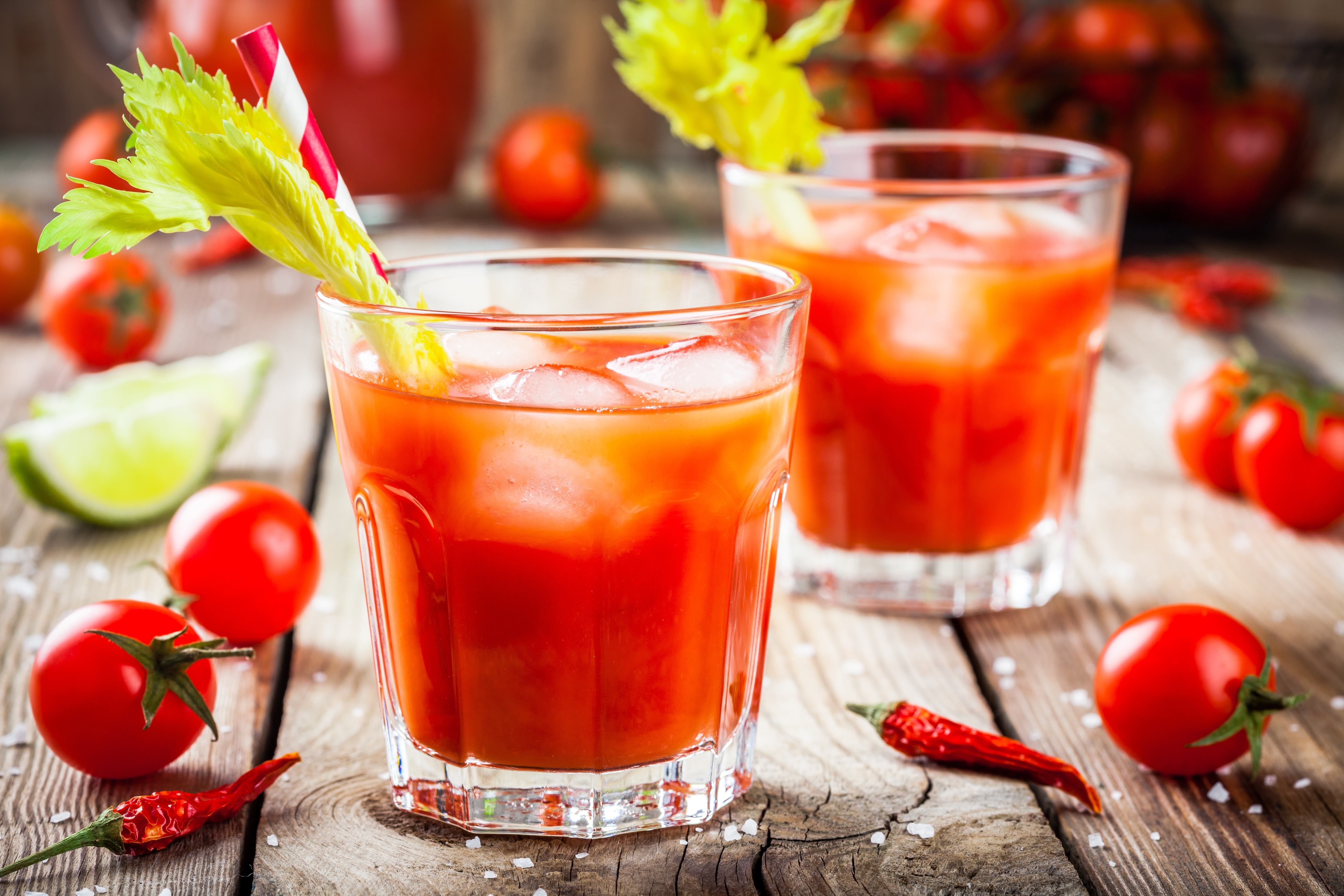 dos vasos de zumo de tomate con una ramita de apio
