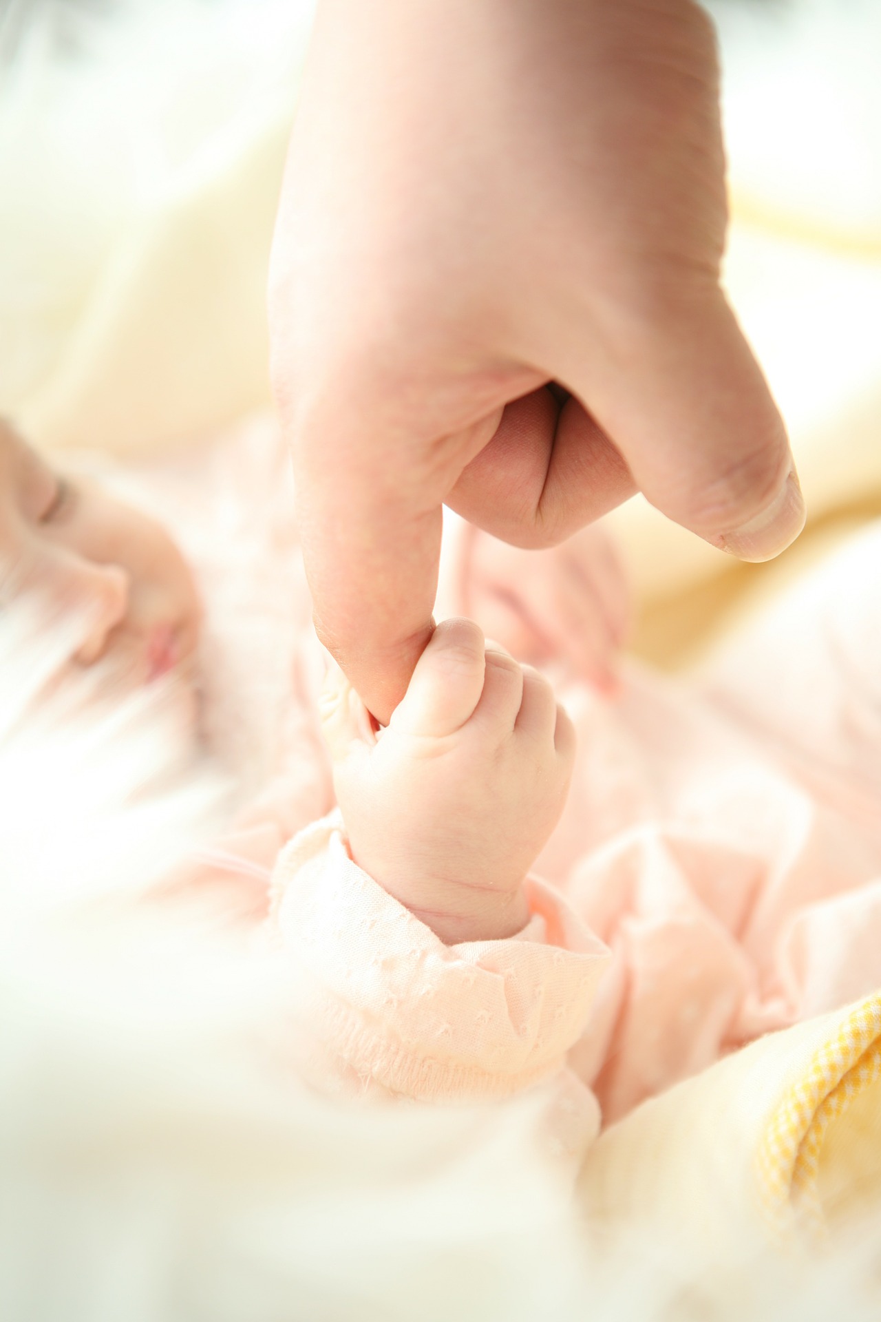 Bebé agarrado a un dedo