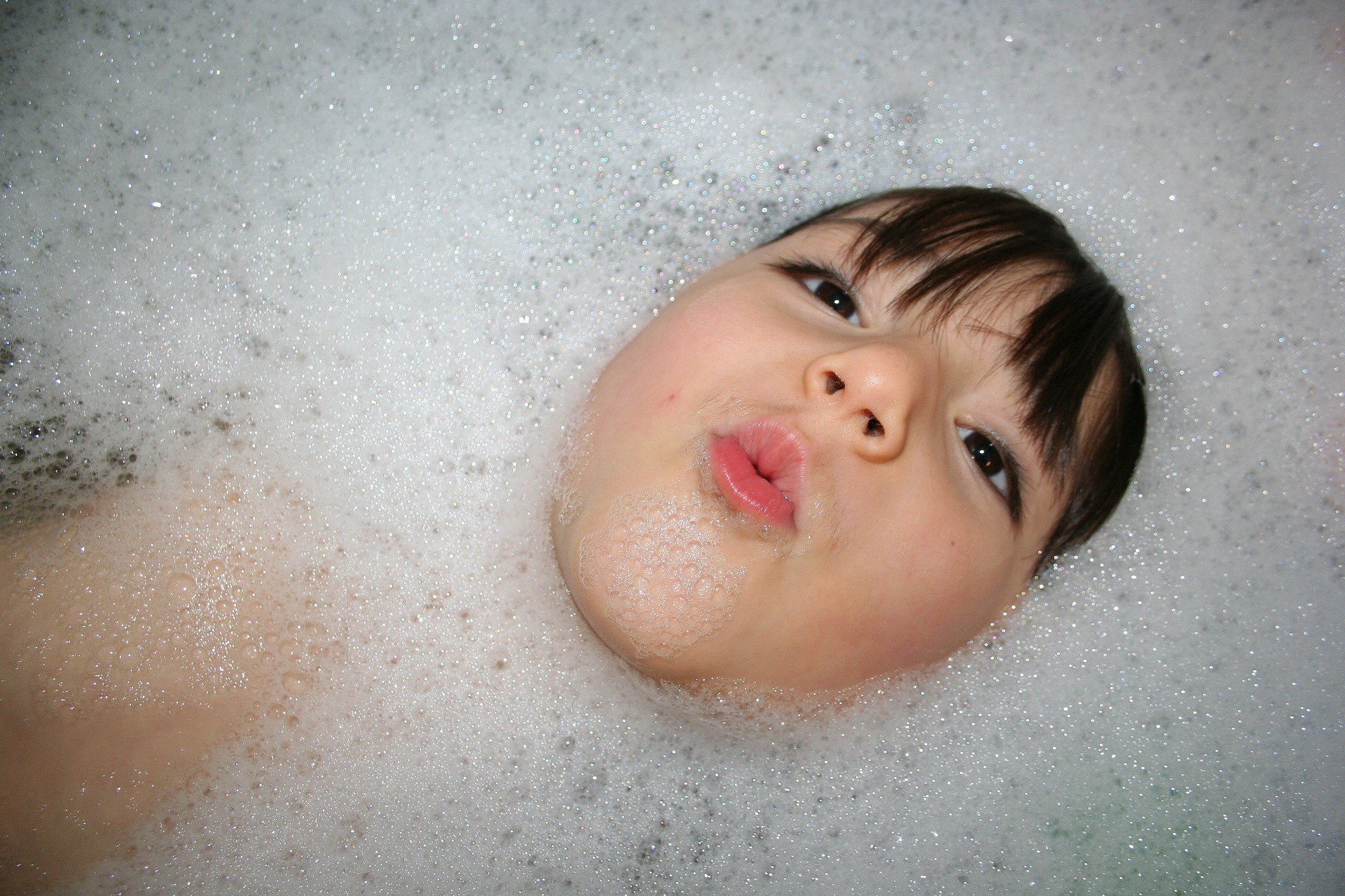 Cabeza de niño saliendo de baño de espuma