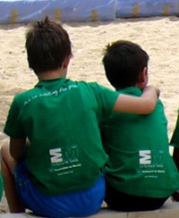 Niños de espaldas sentados en el arenero