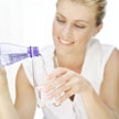Mujer sonriente llenando un vaso de agua