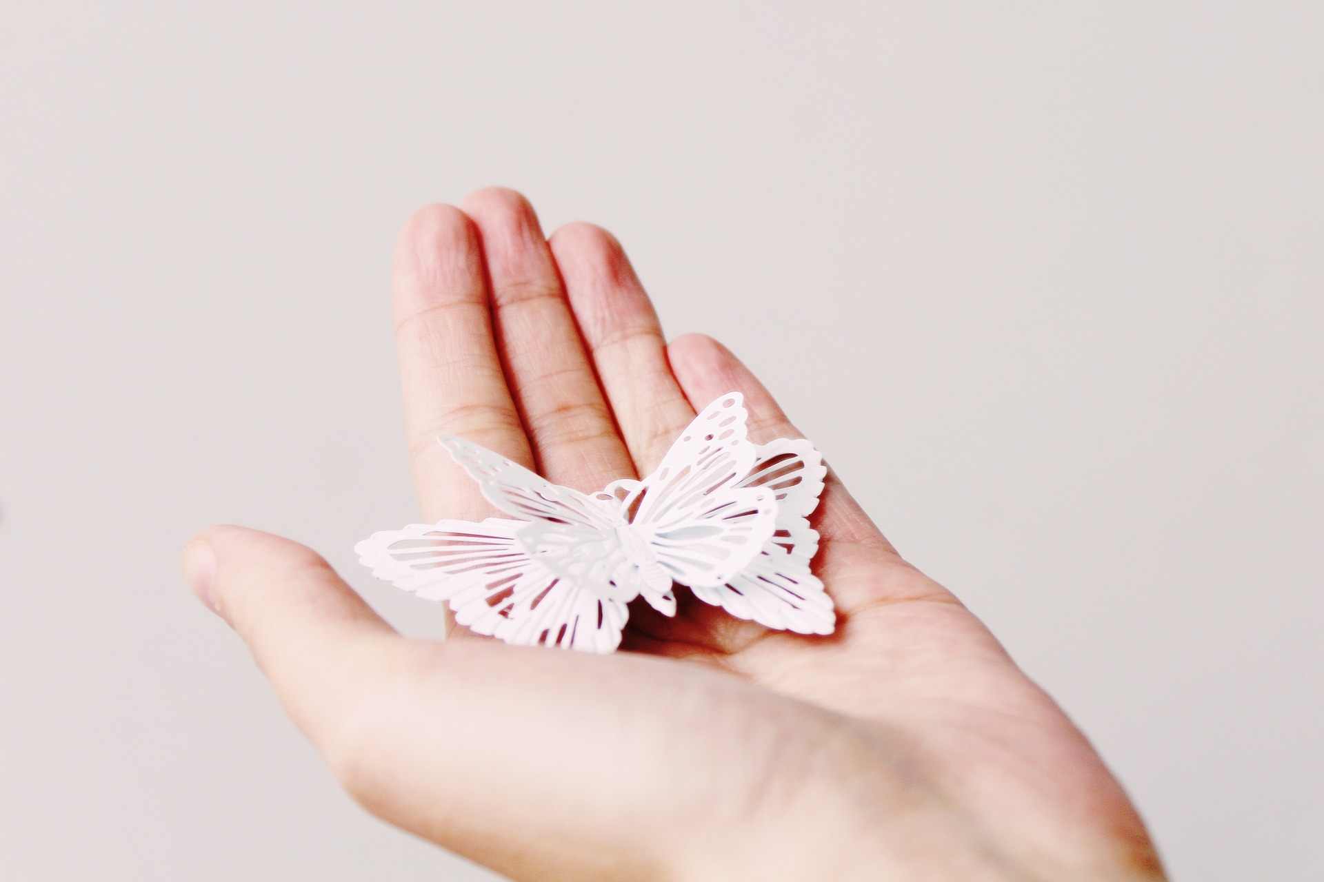 mano con mariposa de papel