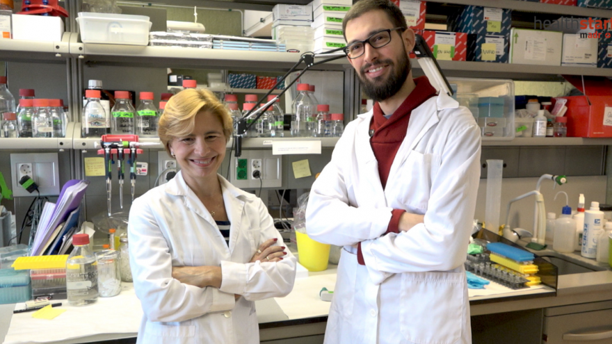 Dos investigadores, mujer a la izquierda y hombre a la derecha, delante de un laboratorio