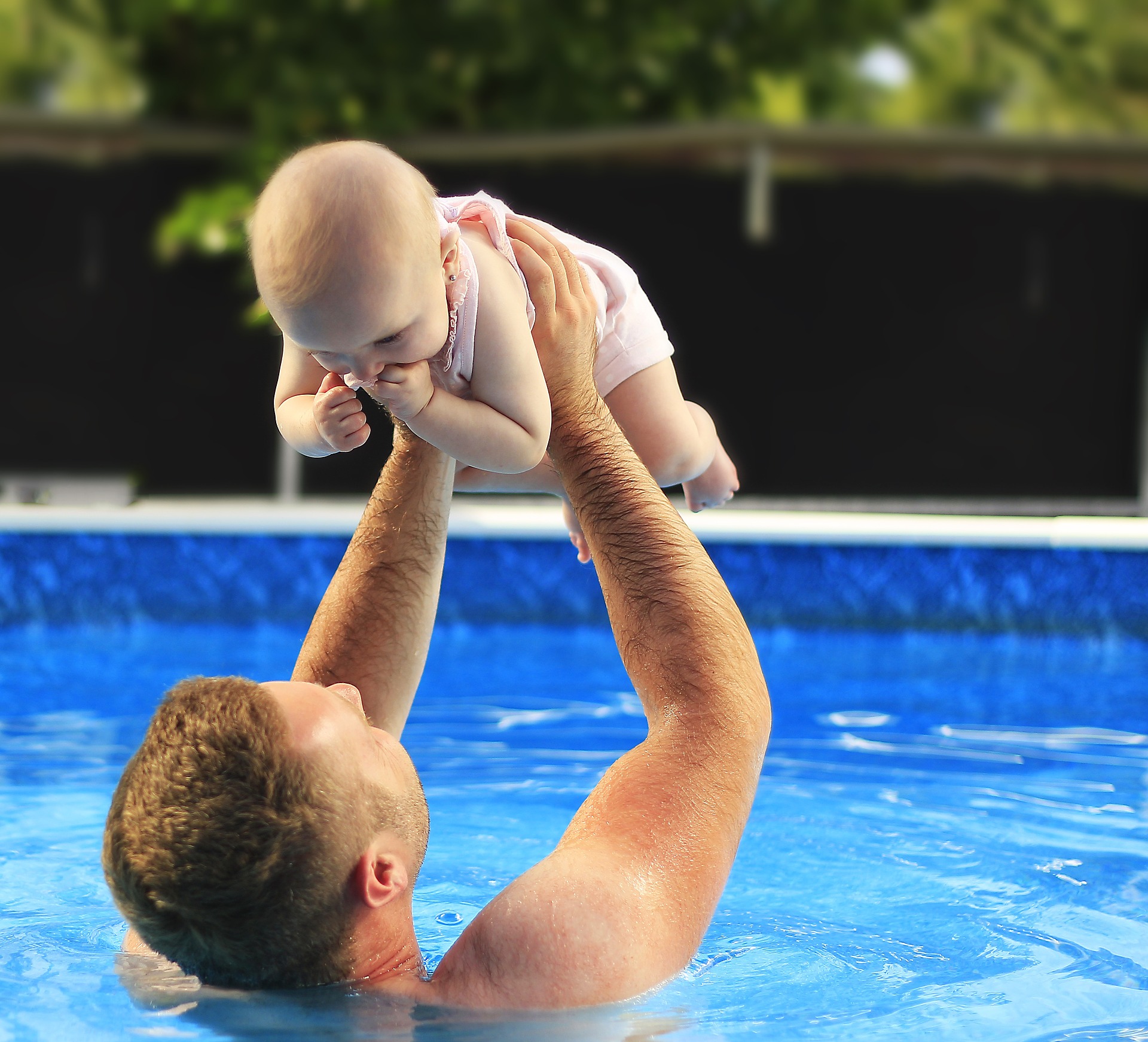 Padre jugando con bebé en piscina