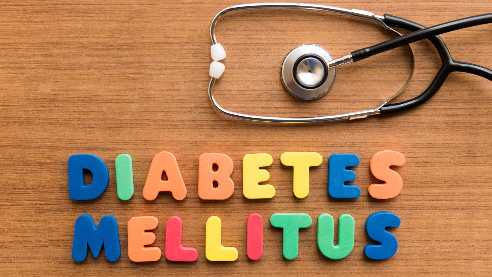 Fonendoscopio sobre fondo de madero y las palabras diabetes mellitus