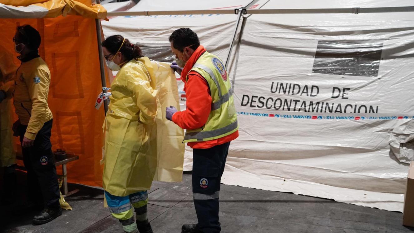 Compañeros de SAMUR - Ayuntamiento de Madrid ayudando a profesionales del SUMMA 112 en la colocación del Equipo de Protección Individual 