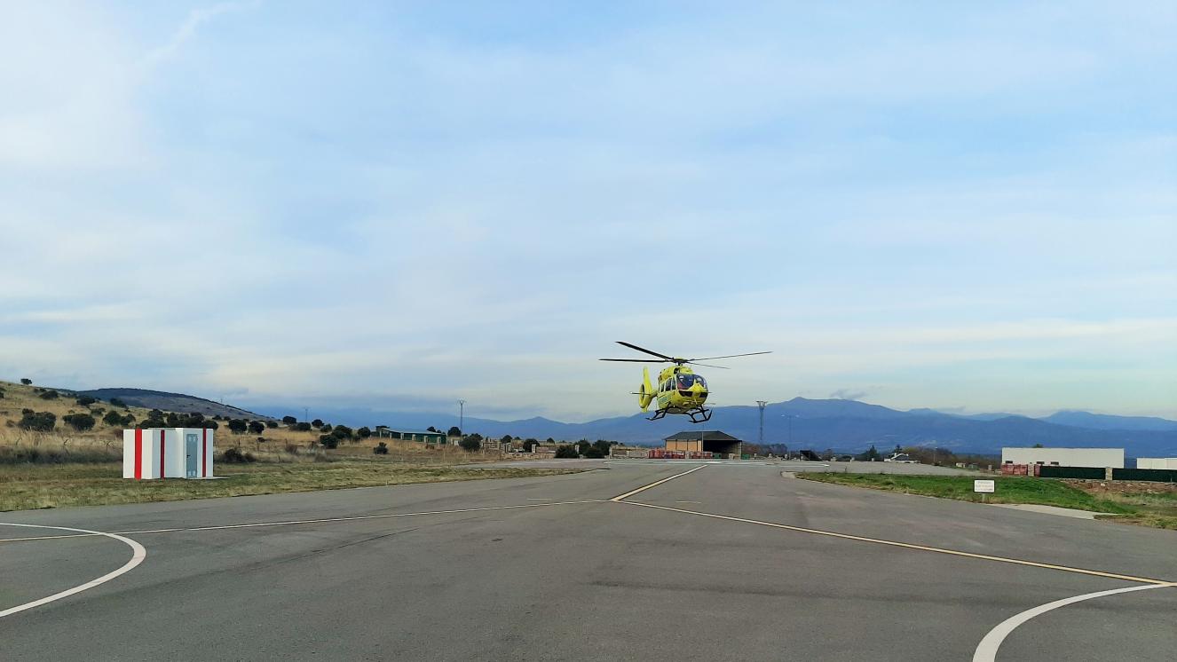 Helicóptero medicalizado del SUMMA 112 realizando maniobras de aproximación para tomar tierra en la base de Lozoyuela