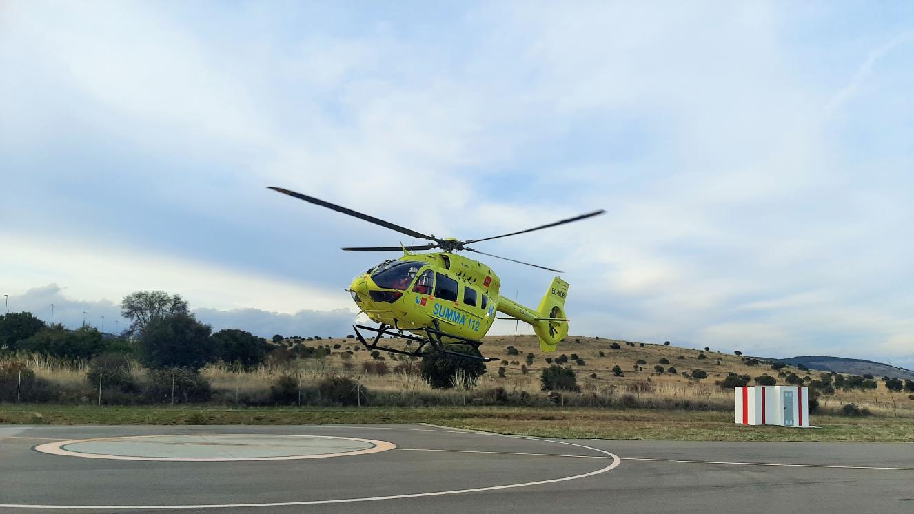 Helicóptero medicalizado del SUMMA 112 realizando maniobras de aproximación para tomar tierra en la base de Lozoyuela