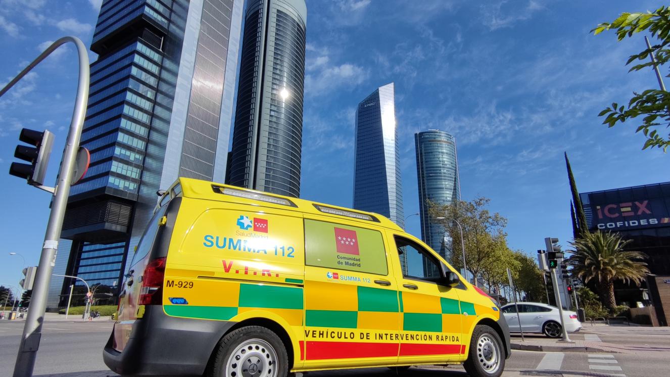Vehículo de Intervención Rápida del SUMMA 112 estacionado junto a las cuatro torres de Madrid