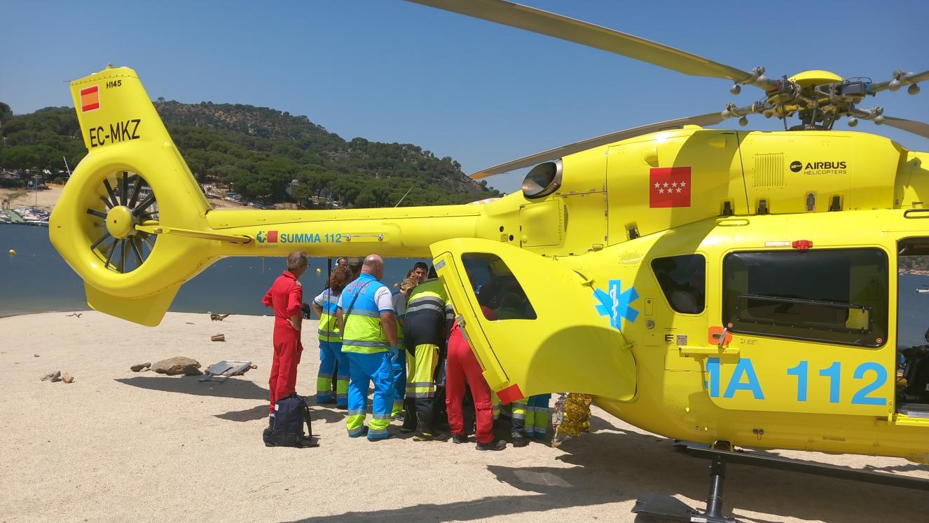 Helicóptero del SUMMA 112 en la Playa del Muro con personal del SUMMA 112 introduciendo al paciente en el interior del Helicóptero para su traslado al centro hospitalario.