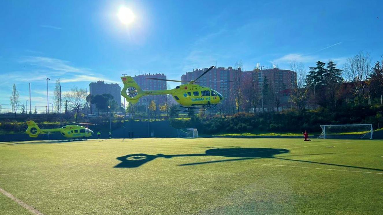 Helicóptero del SUMMA 112 realizando el despegue mientras el otro helicóptero del SUMMA 112 se encuentra posado todo ello en un Campo de Fútbol de Madrid