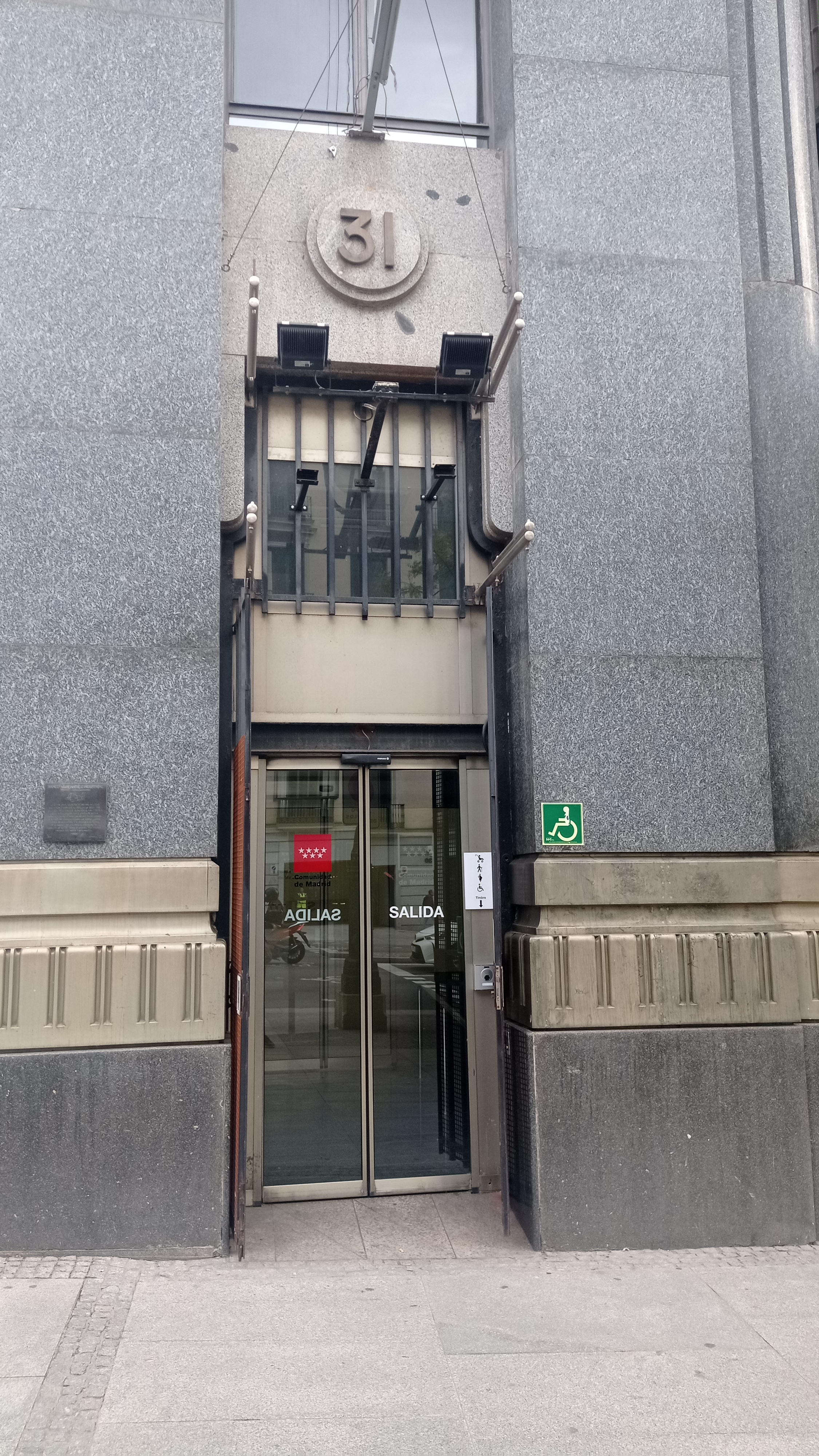 Puerta auxiliar. Alcalá 31 Puerta de hierro con un número 31 arriba