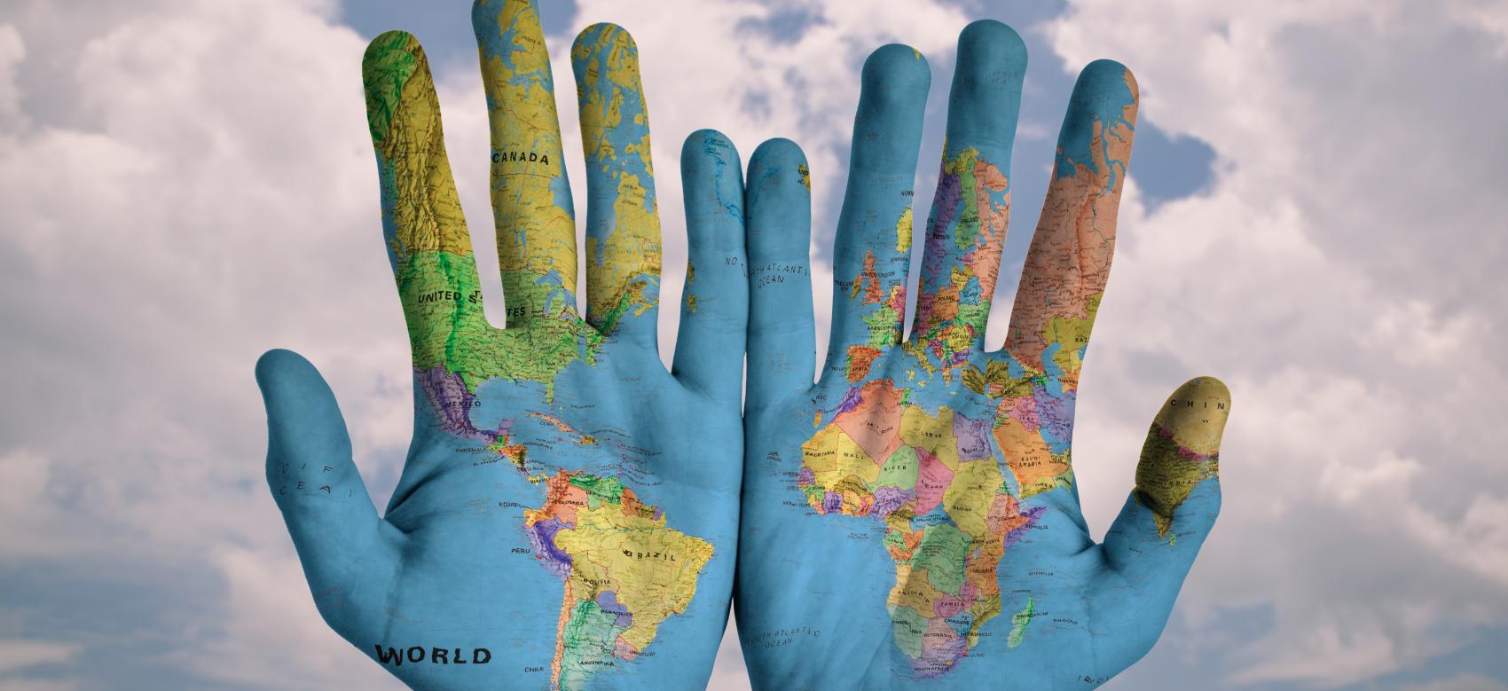 Hands with the image of a world map painted on them
