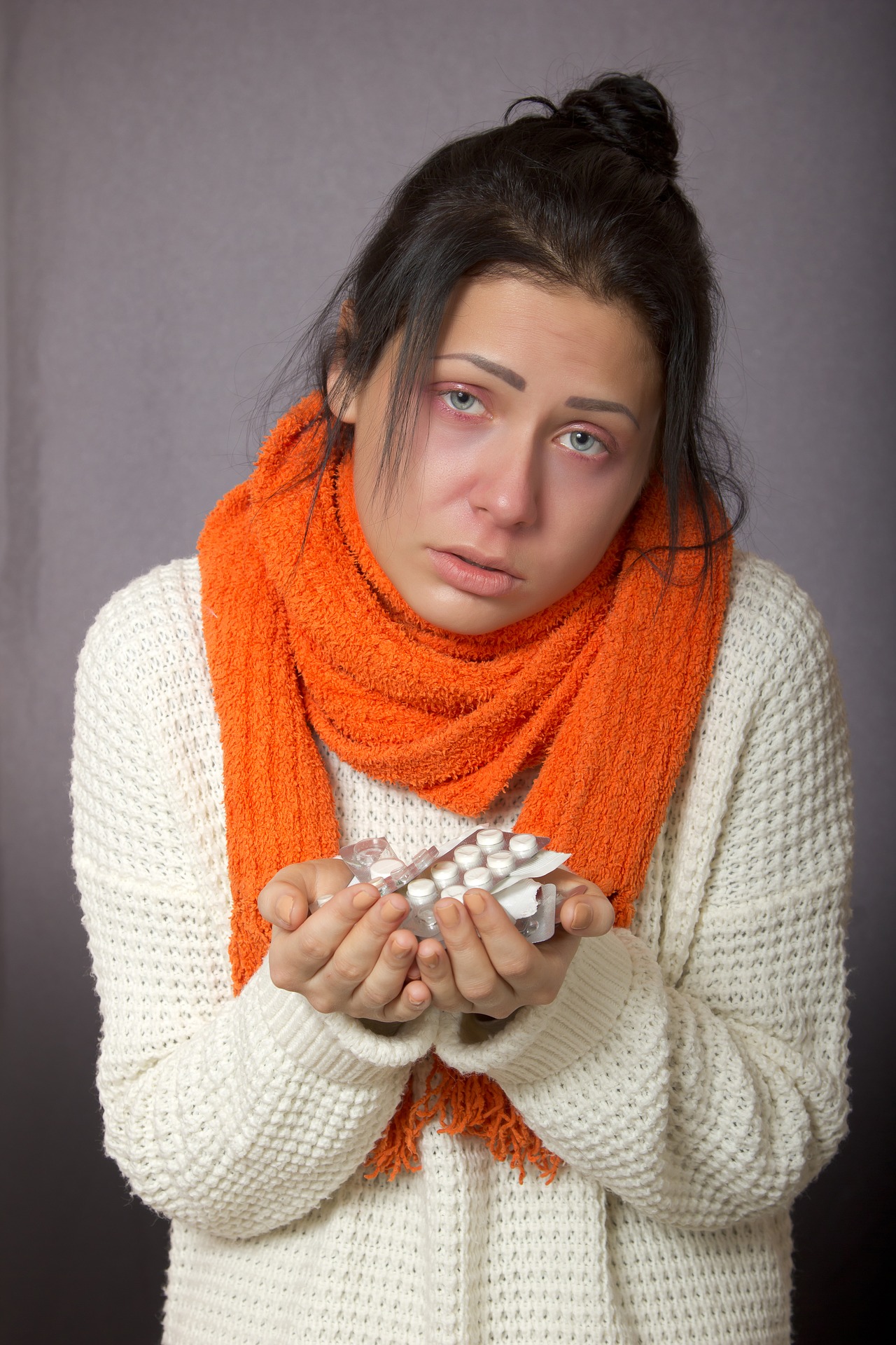 Persona enferma con medicamentos en la mano