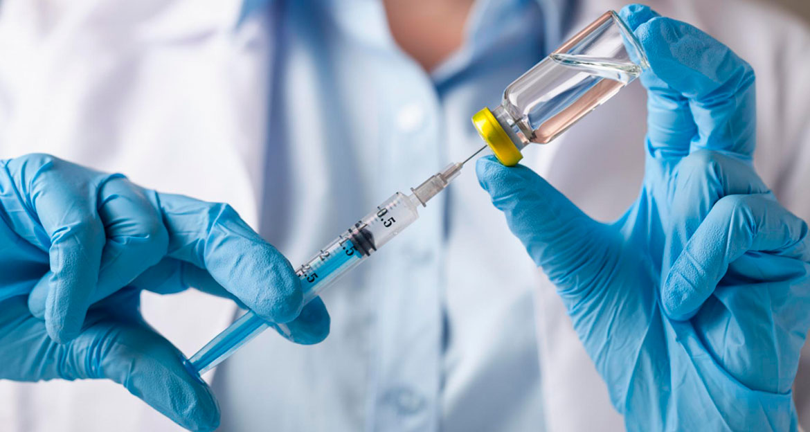 Syringe injected into a vaccine bottle