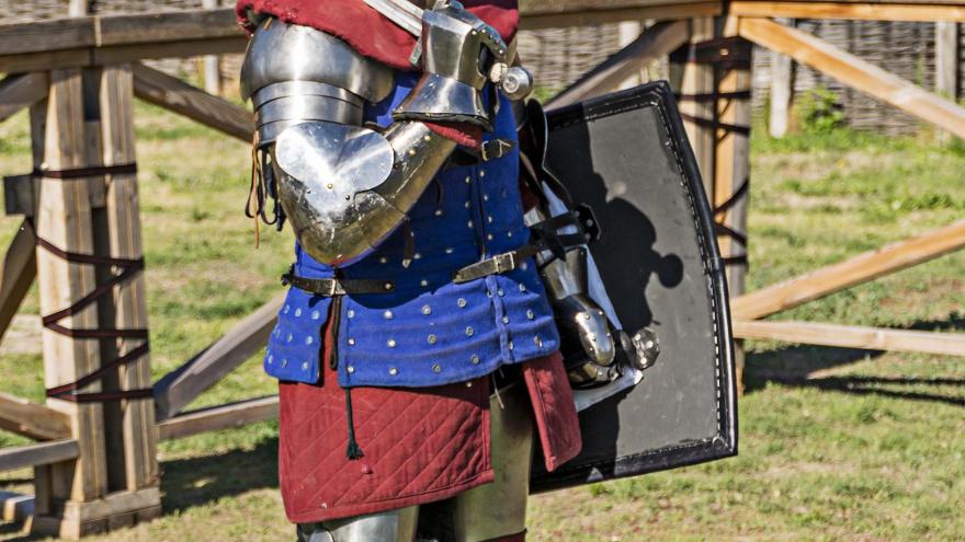 Caballero con armadura, escudo y espada al hombro