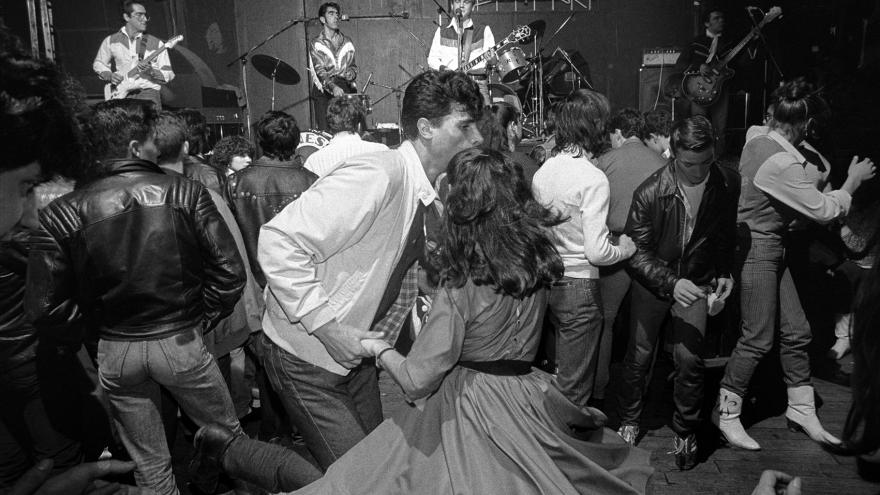 Grupo de gente bailando en una sala de fiestas.