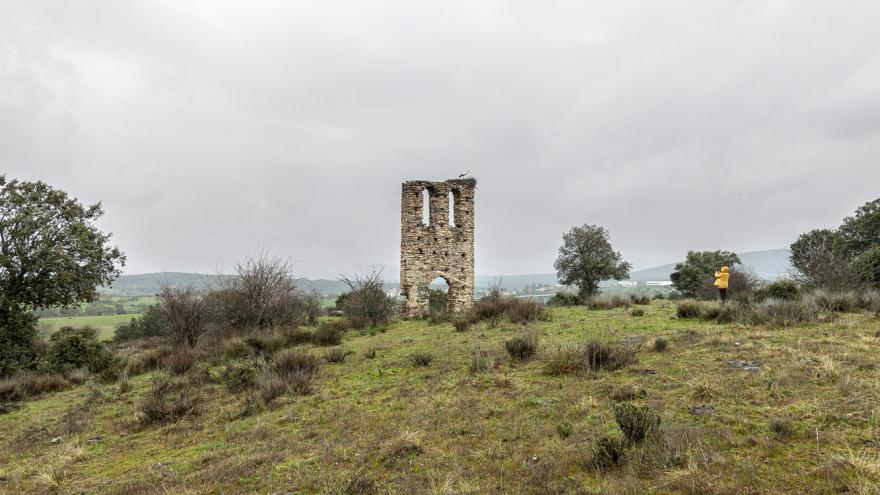 Una persona fotografía los restos de una iglesia en un monte.