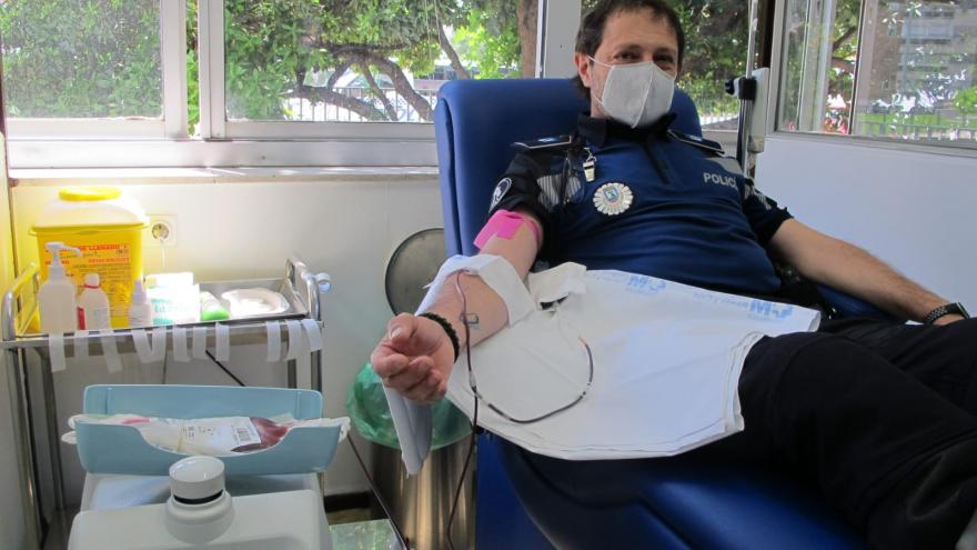 Policía donando sangre al fondo