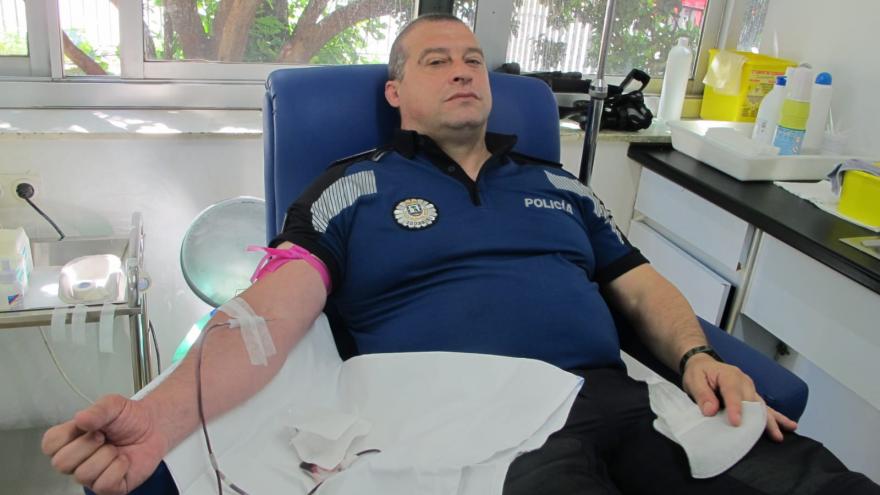 policía donando sangre en un plano medio.