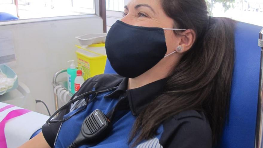 Policía mujer donando en una imagen de perfil izquierdo