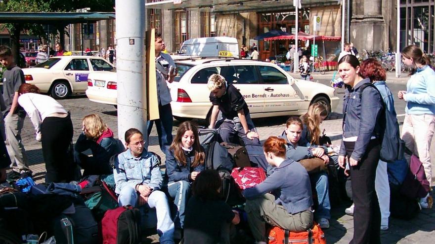 Grupo de jóvenes con maletas y mochilas en la calle