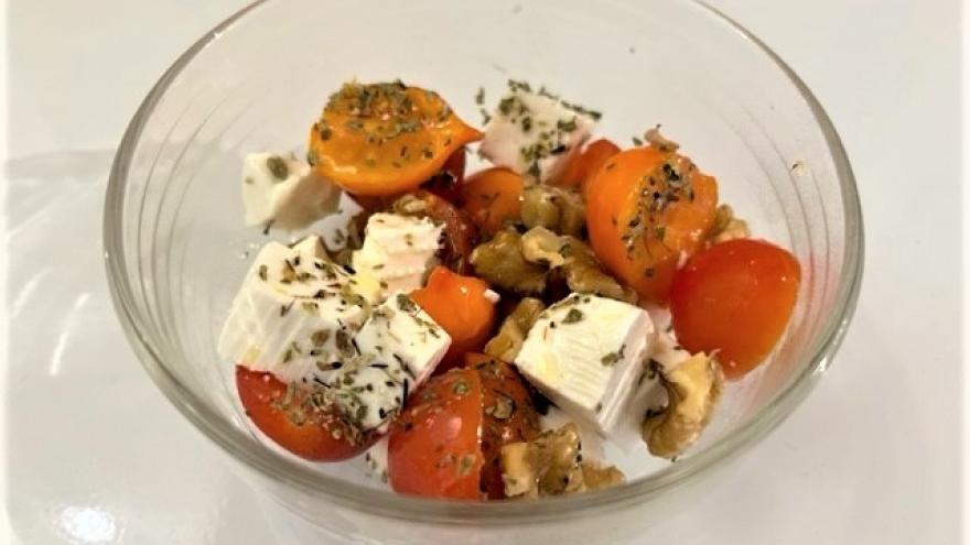 Ensalada de tomate, queso y nueces en un bol trasparente 