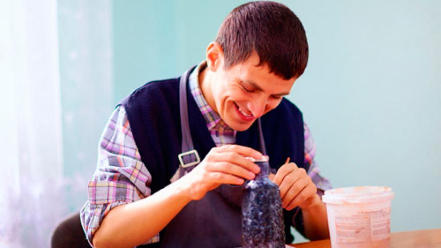 Joven con discapacidad intelectual trabajando en una pieza cerámica