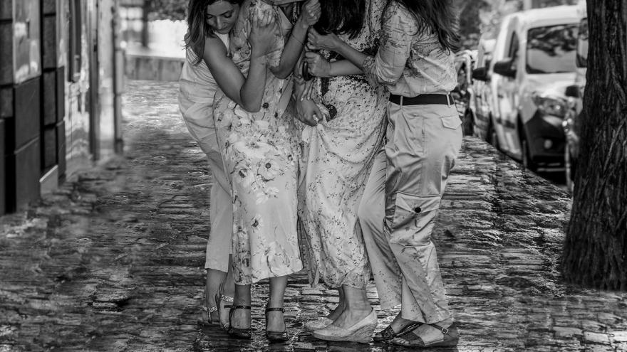 Fotografía en blanco y negro de jóvenes bajo paraguas