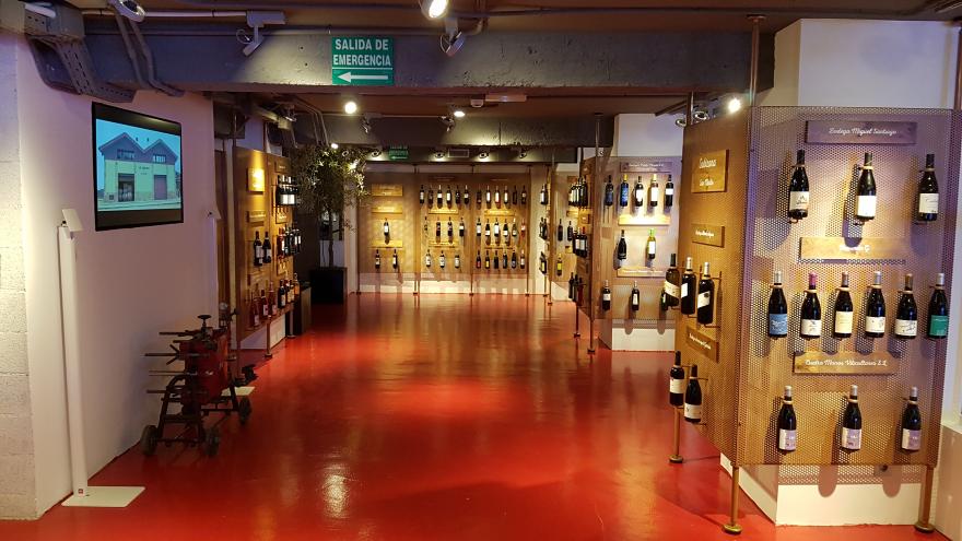 Botellas de la DO Vinos de Madrid enganchadas de modo individual a varios paneles formando hileras