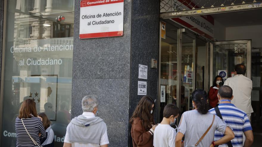 Imagen de la entrada de la Oficina de Atención al Ciudadano de Gran Vía con personas esperando a las puertas