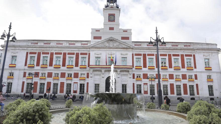 Fachada de la Real Casa de Correos decorada con la bandera española