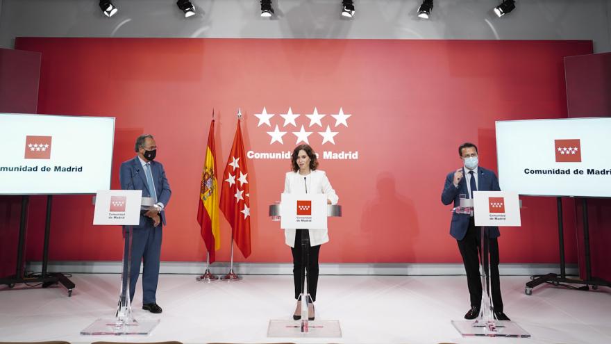 La presidenta en el medio frente al atril a su lado izquierdo Enrique Ossorio y a su derecho Fernández Lasquetty