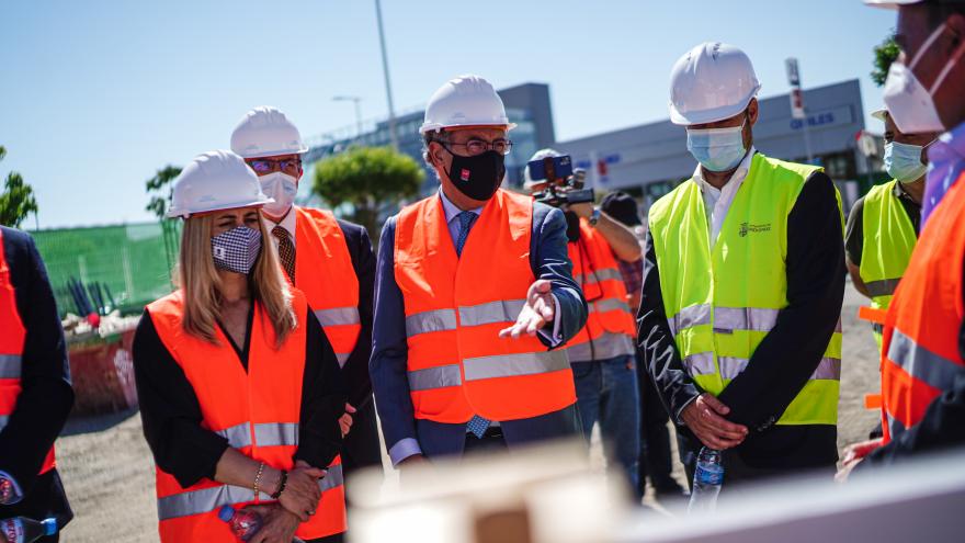 Fotografía de medio cuerpo del consejero explicando el proyecto junto al resto de miembros asistentes con chaleco reflectante y casco