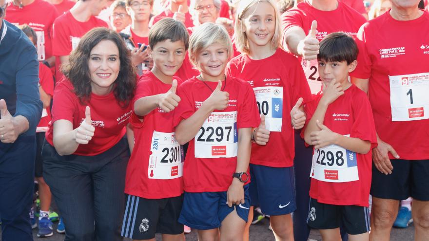 Isabel Díaz Ayuso junto a unos niños participantes en la carrera popular 'Corre por el Niño'