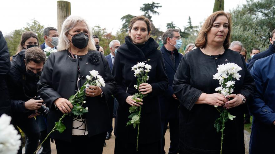 La presidenta de honor de la AVT, la presidenta de la Comunidad de Madrid y la presidenta de la AVT, con flores blancas durante el homenaje