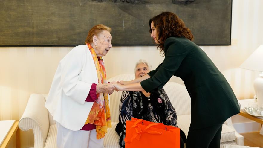 La presidenta ha conocido las experiencias de mujeres que le han obsequiado con una bufanda de los colores de la bandera madrileña