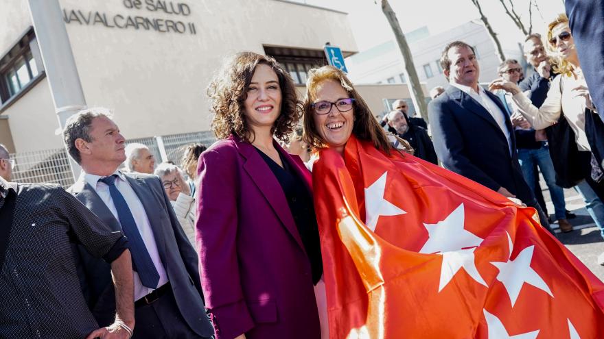 La presidenta con una vecina de Navalcarnero que lleva una bandera de la Comunidad de Madrid