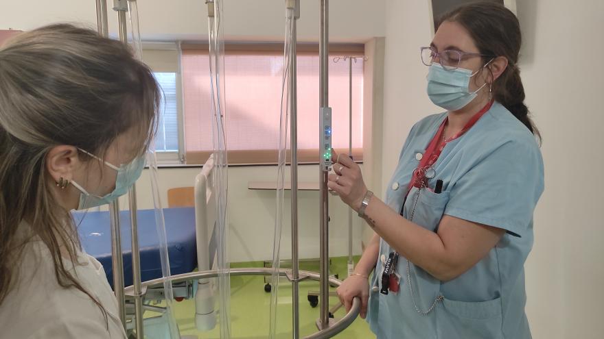 Dos trabajadoras de un hospital frente a una lámpara desinfectante de superficies