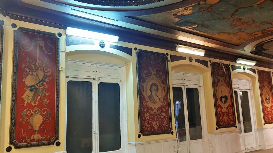 interior image of the living room with mural paintings next to the balcony doors representing illustrious musicians