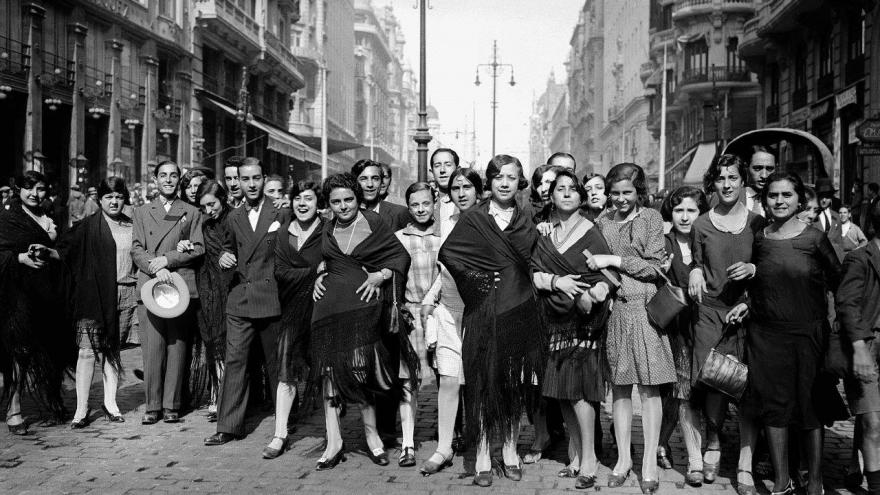 Grupo de personas en la calle mirando y sonriendo a la cámara